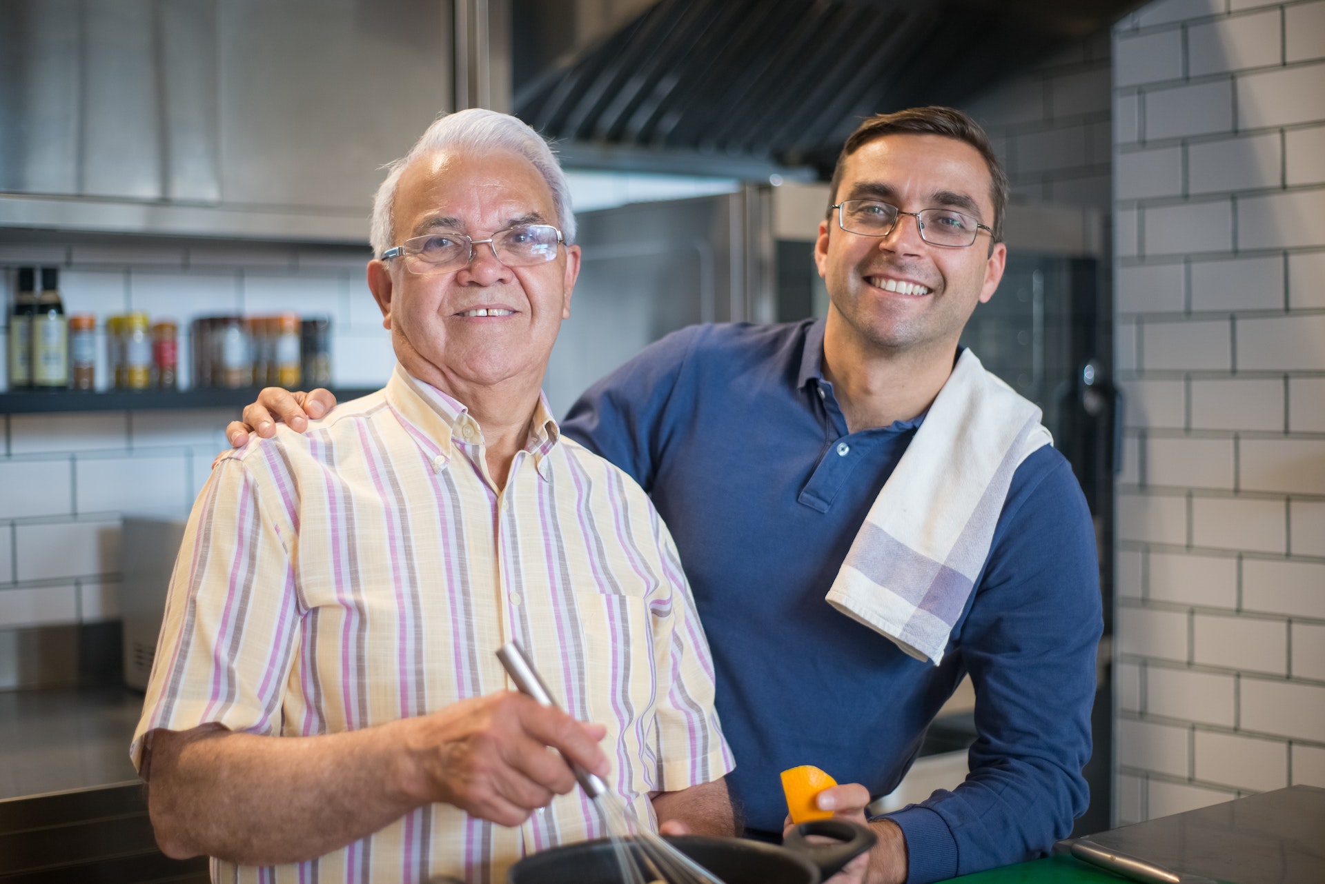 adult son cooking with his elderly father